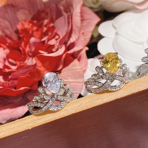 Detailed view of silver crown rings featuring pear-cut clear and yellow gemstones