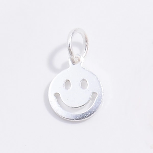 Macro shot of silver hollow smiley face pendant with polished metallic finish