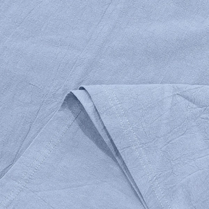 Macro detail of light blue linen fabric showing natural texture and double-stitch sewing