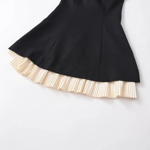 Gros plan d'une robe décontractée noire avec ourlet plissé beige contrasté en mélange