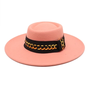 Detail of pink wool fedora with flat top, featuring black ribbon and gold metal chain link