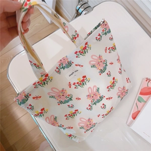 Close-up of cotton handbag with pink rabbit and flower prints featuring a fabric label