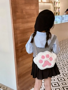 Detail of white plush cat paw shoulder bag featuring pink pads and golden chain strap