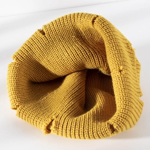 Distressed mustard yellow knit beanie featuring ribbed texture and street style rips
