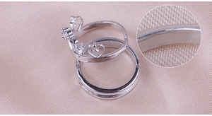 Macro shot of silver crown rings for couples with heart pattern and textured details