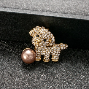 Close-up of a puppy brooch with sparkling rhinestones and a brown pearl detail