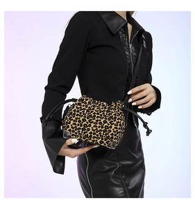 Close-up of leopard print bucket bag with drawstring closure and black leather strap