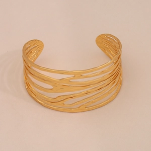 Gros plan du bracelet jonc doré ajouré avec texture martelée et design ouvert réglable