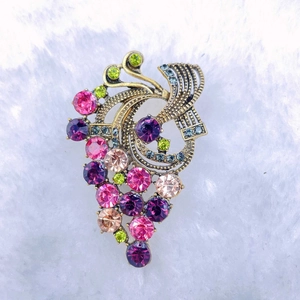 Detailed view of vintage grape brooch with colorful rhinestones on antique gold base