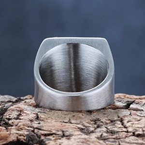 Macro shot of silver brushed metal ring on natural bark texture for an industrial look