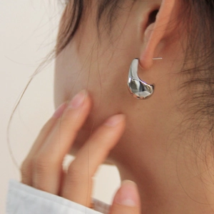 Minimalist silver irregular teardrop earrings with high-polish finish on female model