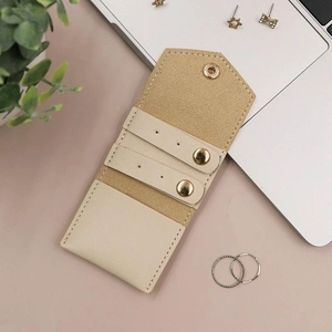 Detail of portable leather jewelry organizer with snap closure and earring storage holes