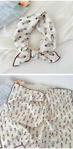 Detailed macro view of cream cotton-linen scarf with dark brown fish patterns and neat edges