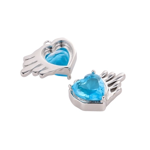 Detailed view of silver heart charms with blue cubic zirconia and wing design