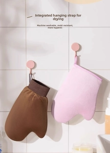 Detail of pink and brown tanning mitts with thumb design hanging on wall hooks