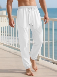 Detail of white linen-style pants featuring adjustable drawstring and mesh texture