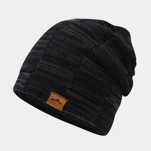 Detail of black winter beanie with waffle knit texture and mountain leather patch logo