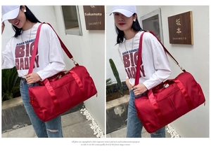 Detail of red large capacity travel bag with waterproof nylon and side shoe compartment