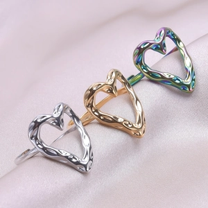 Detail showing gold, silver, and iridescent heart rings with hammered metal texture