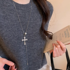 Silver rhinestone cross necklace pendant styled on a model wearing a dark grey sweater
