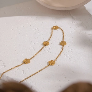 Macro shot of 18K gold-plated stainless steel necklace with delicate clover charms