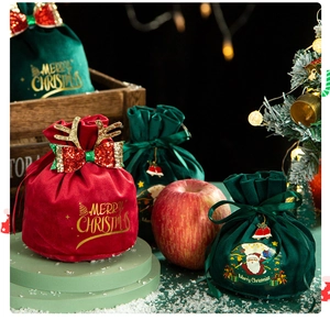 Detail of red and green velvet Christmas gift bags with reindeer antlers and gold text