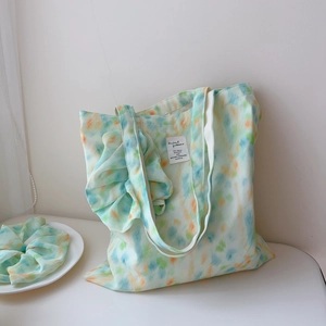 Detail of mint green watercolor tie-dye tote bag with matching scrunchie on white display