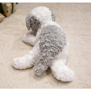 Detail of soft grey and white plush puppy toy resting on a textured cream carpet