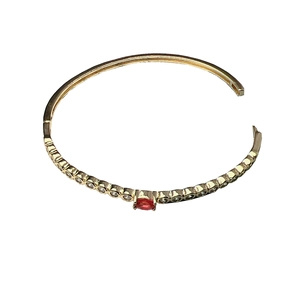 Adjustable gold geometric bracelet with red oval gemstone and white zircon accents