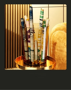 Modern amber transparent storage bin used for magazines on a golden metal tray