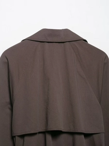 Detail der Rückseite eines dunkelbraunen kurzen Trenchcoats mit präziser Nahtführung