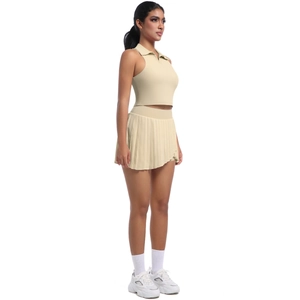 Détail d'un ensemble de sport beige avec haut polo sans manches et jupe plissée courte