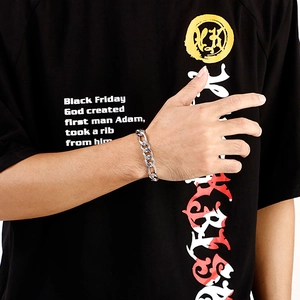 Close-up of polished silver metal chain link bracelet worn on a model's wrist