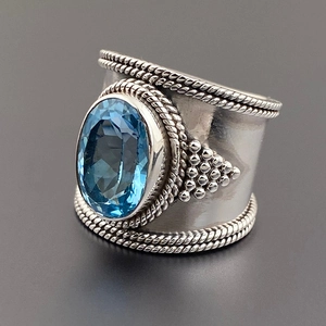 Dettaglio anello etnico in argento con pietra ovale blu e trama a corda intrecciata