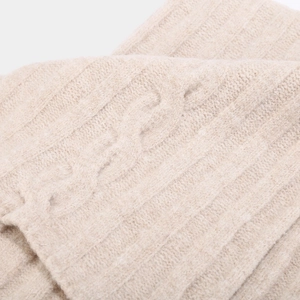 Macro view of beige cable knit and ribbed texture on winter accessories set