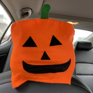 Halloween pumpkin car headrest cover with Jack-o'-lantern face in orange felt fabric