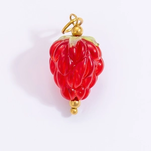 Macro detail of red strawberry pendant with golden hardware for DIY jewelry making