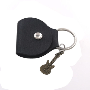 Detail of black leather guitar pick pouch with silver snap and bronze guitar pendant