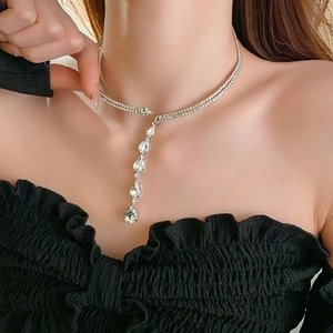 Gros plan d'un collier ras du cou argenté avec pampilles en zircon goutte d'eau sur modèle