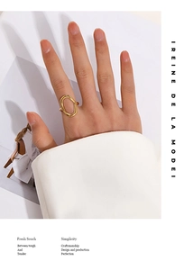 Minimalist oval hollow ring in 18K gold finish worn by model with fashion magazine