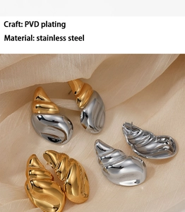 Detail showing PVD plated stainless steel conch earrings on beige silk background