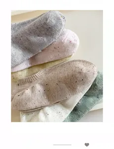 Close-up of stacked cotton ankle socks in Morandi colors with circular logo embroidery