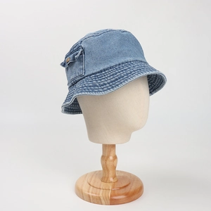 Close-up of denim bucket hat with decorative pocket and vintage metal button detail
