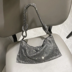 Detail of silver rhinestone mesh handbag featuring a decorative knot on the shoulder strap