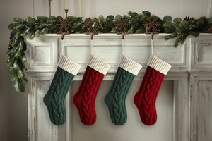Close-up of knit Christmas stockings in red and green hanging on a decorated mantel