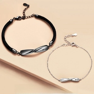 Macro detail of Mobius couple bracelets with No.52 engraving and crystal embellishments