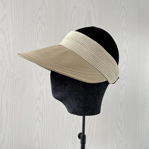 Detail of khaki wide brim sun visor featuring straw patchwork and multi-row stitching