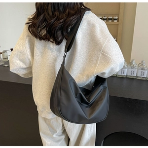 Close-up of the black nylon crescent bag with a minimalist half-moon shape and褶皱 design