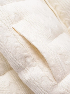 Detailed macro view of cable knit pocket texture on cream white oversized casual cardigan