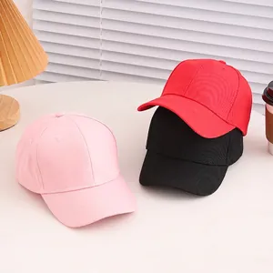 Classic cotton baseball cap set in pink, red and black colors for kids on a white table